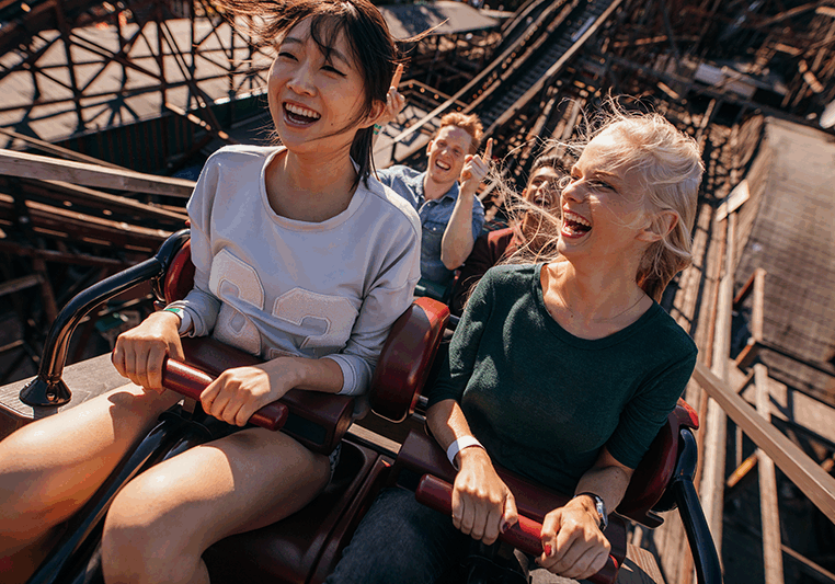 Theme Park Social smiling-young-people-riding-a-roller-coaster Theme Park Social smiling-young-people-riding-a-roller-coaster